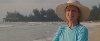 Movie still from “The Descendants” (2011), directed by Alexander Payne – A woman wearing a hat standing in front of the ocean; Close Up shot, Over the shoulder angle