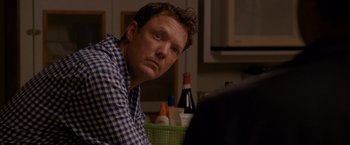 Movie still from “The Descendants” (2011), directed by Alexander Payne – A person sitting at a table in a room; Close Up shot, Over the shoulder angle