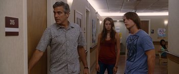 Movie still from “The Descendants” (2011), directed by Alexander Payne – A man and two women standing in a hospital hallway; Medium shot, Over the shoulder angle