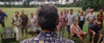 Movie still from “The Descendants” (2011), directed by Alexander Payne – A group of men standing in front of each other in a grassy field; Medium shot, Over the shoulder angle