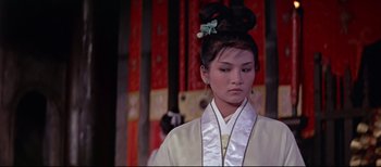 A young woman in a white kimono with a green flower in her hair