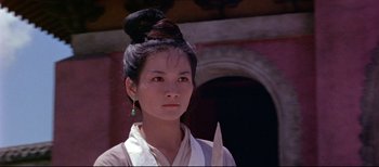 A woman with a bun and a green earring