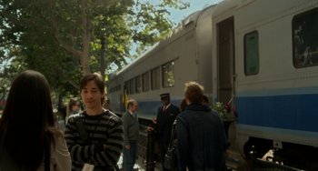 Movie still from “Comet” (2014), directed by Sam Esmail – A group of people standing next to each other near a train; Medium shot, Over the shoulder angle