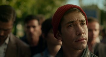 Movie still from “Comet” (2014), directed by Sam Esmail – A young man wearing a red hat looking up at the sky; Close Up shot, Low angle