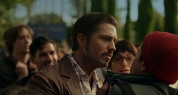 Movie still from “Comet” (2014), directed by Sam Esmail – A person wearing glasses and a brown jacket; Close Up shot, Over the shoulder angle