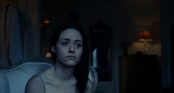 Movie still from “Comet” (2014), directed by Sam Esmail – A woman sitting on a couch in a dark room; Close Up shot, Over the shoulder angle
