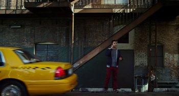 Movie still from “Comet” (2014), directed by Sam Esmail – A man standing on the side of the street talking on a phone; Wide shot, Low angle