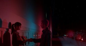 Movie still from “Comet” (2014), directed by Sam Esmail – A man shaking hands with another man in a parking lot; Medium shot, Over the shoulder angle
