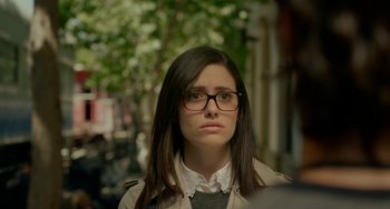 Movie still from “Comet” (2014), directed by Sam Esmail – A young woman with glasses is standing in the street; Close Up shot, Over the shoulder angle