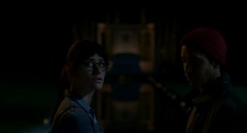 Movie still from “Comet” (2014), directed by Sam Esmail – A woman wearing glasses standing next to a man wearing glasses; Close Up shot, Over the shoulder angle