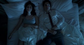 Movie still from “Comet” (2014), directed by Sam Esmail – A man and a woman laying in a bed at night; Medium shot, Overhead angle