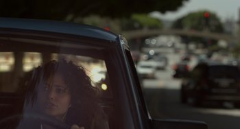 Movie still from “Comet” (2014), directed by Sam Esmail – A woman sitting in the passenger seat of a car on the street; Close Up shot, Over the shoulder angle