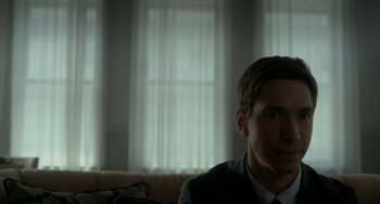 Movie still from “Comet” (2014), directed by Sam Esmail – A man in a suit sitting on a couch in front of a window; Close Up shot, Over the shoulder angle