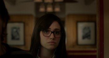 Movie still from “Comet” (2014), directed by Sam Esmail – A woman wearing glasses and headphones looking at the camera; Close Up shot, Over the shoulder angle