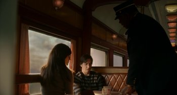 Movie still from “Comet” (2014), directed by Sam Esmail – A man and a woman sitting at a table in front of a waiter; Medium shot, Over the shoulder angle