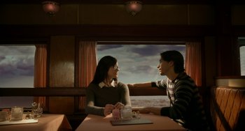 Movie still from “Comet” (2014), directed by Sam Esmail – A man and a woman sitting at a dinner table; Medium shot, Over the shoulder angle