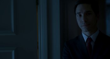 Movie still from “Comet” (2014), directed by Sam Esmail – A man wearing a suit and tie standing in front of a window; Close Up shot, Low angle