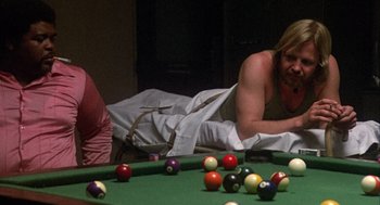 Movie still from “Coming Home” (1978), directed by Hal Ashby – A man laying on the ground next to a pool table; Medium shot, Over the shoulder angle