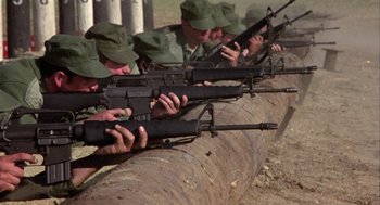 Movie still from “Coming Home” (1978), directed by Hal Ashby – A group of men in green hats are holding guns; Wide shot, Low angle