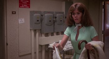 Movie still from “Coming Home” (1978), directed by Hal Ashby – A woman in a green dress holding a bag; Medium shot, Low angle