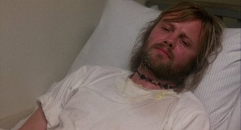 Movie still from “Coming Home” (1978), directed by Hal Ashby – A man with long hair and beard laying in a bed; Close Up shot, High angle
