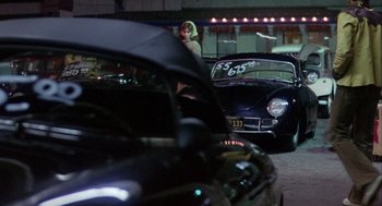 Movie still from “Coming Home” (1978), directed by Hal Ashby – A woman standing in front of a parked car at night; Wide shot, Over the shoulder angle