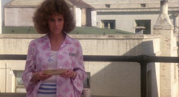 Movie still from “Coming Home” (1978), directed by Hal Ashby – A woman in a pink shirt holding a box; Medium shot, Over the shoulder angle