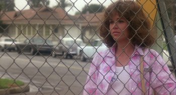 Movie still from “Coming Home” (1978), directed by Hal Ashby – A woman standing in front of a chain link fence; Medium shot, Over the shoulder angle