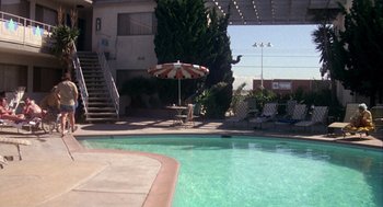 Movie still from “Coming Home” (1978), directed by Hal Ashby – An outdoor pool with a table and umbrella in it; Extreme Wide shot, High angle