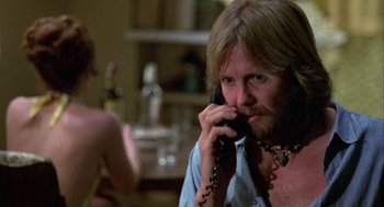Movie still from “Coming Home” (1978), directed by Hal Ashby – A man talking on a phone while a woman looks on; Close Up shot, Over the shoulder angle