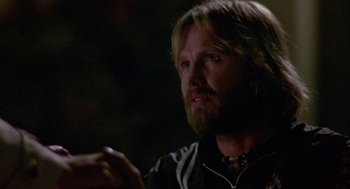 Movie still from “Coming Home” (1978), directed by Hal Ashby – A man with long hair and a goatee is holding something; Close Up shot, Over the shoulder angle
