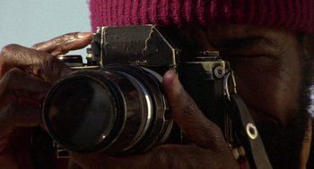 Movie still from “Coming Home” (1978), directed by Hal Ashby – A person holding an old camera in their hand; Extreme Close Up shot, Low angle