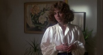 Movie still from “Coming Home” (1978), directed by Hal Ashby – A woman in a white shirt is standing in front of a painting; Medium shot, Over the shoulder angle