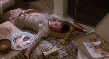 Movie still from “Coming Home” (1978), directed by Hal Ashby – A young man laying on the floor next to a plate of pizza; Medium shot, High angle