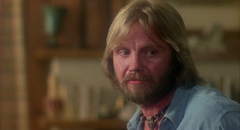 Movie still from “Coming Home” (1978), directed by Hal Ashby – A person with long blond hair and a beard; Close Up shot, Over the shoulder angle