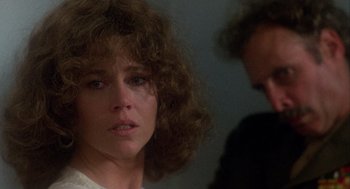 Movie still from “Coming Home” (1978), directed by Hal Ashby – A woman with curly brown hair looking at the camera; Close Up shot, Over the shoulder angle
