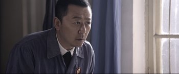 Movie still from “Coming Home” (2014), directed by Yimou Zhang – A person wearing a suit and tie; Close Up shot, Low angle