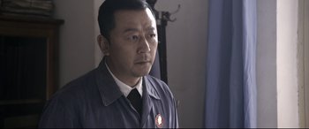 Movie still from “Coming Home” (2014), directed by Yimou Zhang – A man wearing a suit and a tie; Close Up shot, Over the shoulder angle