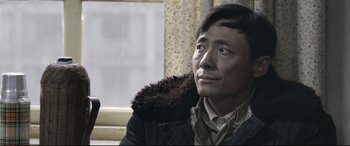 Movie still from “Coming Home” (2014), directed by Yimou Zhang – A man in a black jacket looking to his left; Close Up shot, Over the shoulder angle