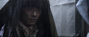 Movie still from “Coming Home” (2014), directed by Yimou Zhang – A man in a fur hat looking out of a window; Close Up shot, High angle