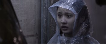 Movie still from “Coming Home” (2014), directed by Yimou Zhang – A young woman wearing a plastic rain coat; Close Up shot, Low angle