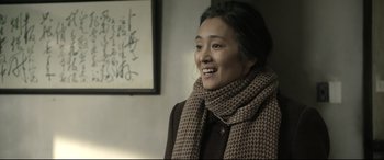 Movie still from “Coming Home” (2014), directed by Yimou Zhang – A woman wearing a scarf and a brown jacket; Close Up shot, Over the shoulder angle