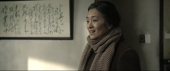 Movie still from “Coming Home” (2014), directed by Yimou Zhang – A woman wearing a scarf and a brown jacket; Close Up shot, Over the shoulder angle