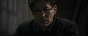 Movie still from “Coming Home” (2014), directed by Yimou Zhang – A person wearing glasses; Close Up shot, Over the shoulder angle