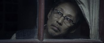 Movie still from “Coming Home” (2014), directed by Yimou Zhang – A man wearing glasses looking out of a window; Close Up shot, Over the shoulder angle