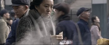 Movie still from “Coming Home” (2014), directed by Yimou Zhang – A woman holding a piece of paper in her hand; Close Up shot, Over the shoulder angle