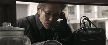 Movie still from “Coming Home” (2014), directed by Yimou Zhang – A man with glasses is talking on a phone; Close Up shot, Low angle