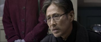 Movie still from “Coming Home” (2014), directed by Yimou Zhang – A person wearing glasses; Close Up shot, Over the shoulder angle