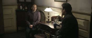 Movie still from “Coming Home” (2014), directed by Yimou Zhang – Two people are sitting at a table talking to each other; Medium shot, Over the shoulder angle