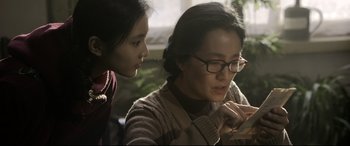 Movie still from “Coming Home” (2014), directed by Yimou Zhang – A woman and a girl looking at a cell phone; Close Up shot, Over the shoulder angle